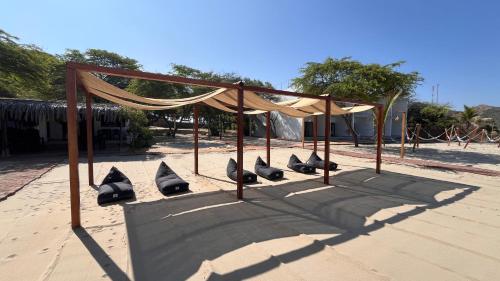 a group of shoes sitting on the sand under a canopy at Las Hamacas in Canoas De Punta Sal