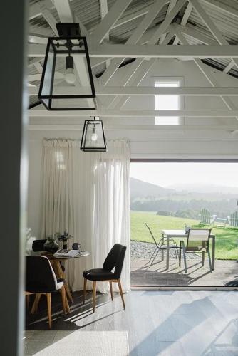 a living room with a table and chairs and a window at Braelee Bower in Rollands Plains