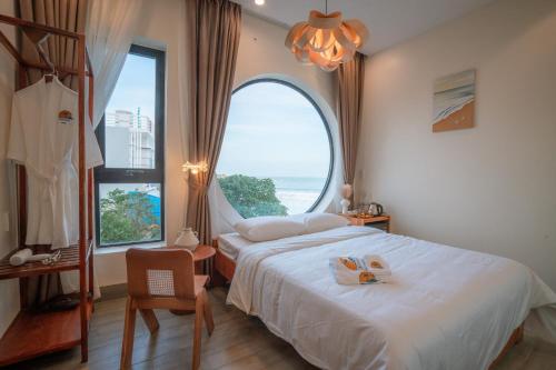 a bedroom with a bed and a large window at Sunsea House-Đá Đĩa Phú Yên in Tuy An