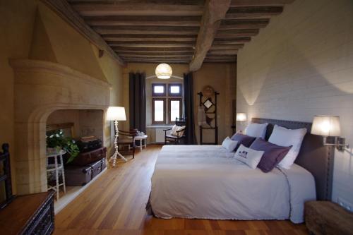 - une chambre avec un grand lit et une cheminée dans l'établissement Le Manoir du Pont Senot, à Noron-la-Poterie