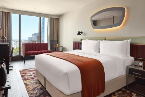 a hotel room with a large bed and a large window at Hotel Indigo Auckland by IHG in Auckland