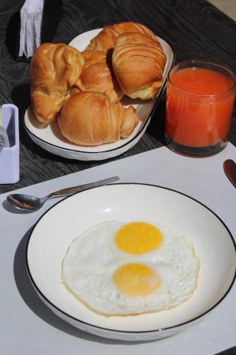two plates of eggs and croissants on a table at Las Hamacas in Canoas De Punta Sal