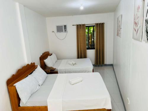 a white room with two beds and a couch at GJEs Lodge and guest house in Basdiot