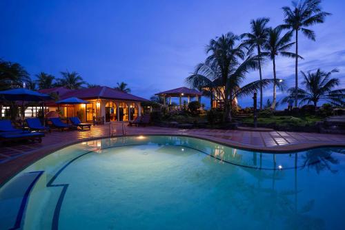a swimming pool at a resort at night at Blue Star Dive and Resort in Anda