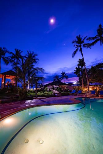 an empty swimming pool at night with a moon at Blue Star Dive and Resort in Anda