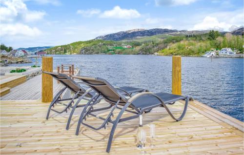 two chairs sitting on a dock next to the water at Amazing Home In Skjoldastraumen in Skjoldastraumen