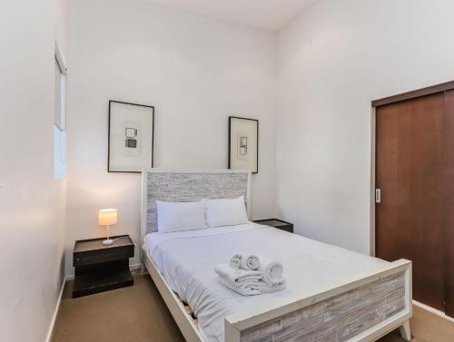 a bedroom with a bed with towels on it at Luxury Oceanfront Haven with a Private Rooftop Spa in Kingscliff