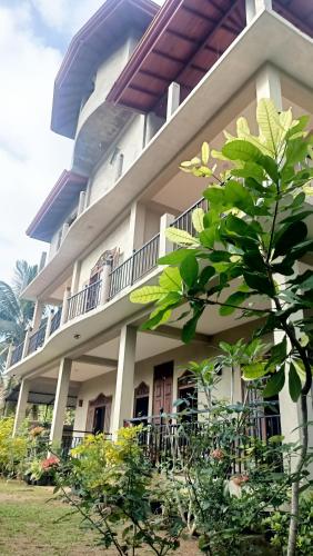 a large white building with a balcony at Sunrise Relax Inn in Beruwala