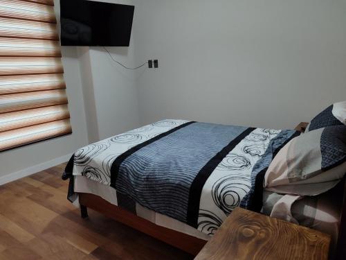a bedroom with a bed with a black and white blanket at Céntrico y confortable, 2 camas in La Paz