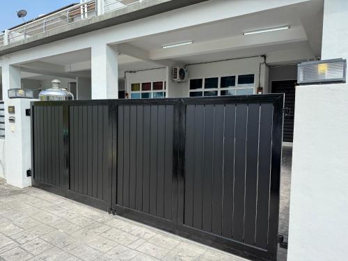 a black gate in front of a house at BEDONG GOLF VILLA in Bedung