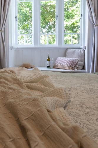 a bed with a blanket and a window in a room at SEASIDE HAVEN Luxe Four BR Oasis with Plunge Pool in Brisbane