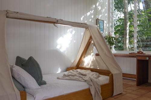 a bed with a canopy in a room with a window at SEASIDE HAVEN Luxe Four BR Oasis with Plunge Pool in Brisbane