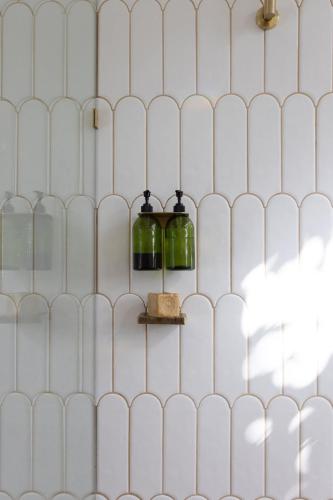 a wall with two glass bottles on a shelf at SEASIDE HAVEN Luxe Four BR Oasis with Plunge Pool in Brisbane