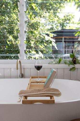 a glass of wine and a laptop on a kitchen counter at SEASIDE HAVEN Luxe Four BR Oasis with Plunge Pool in Brisbane