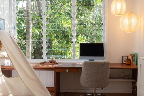 a desk with a computer in front of a window at SEASIDE HAVEN Luxe Four BR Oasis with Plunge Pool in Brisbane