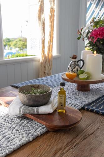 a table with a bottle of oil and a bowl of fruit at SEASIDE HAVEN Luxe Four BR Oasis with Plunge Pool in Brisbane