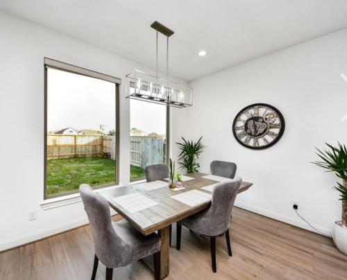 a dining room with a table and chairs and a clock at Prívate Room In Cypress in Hot Wells