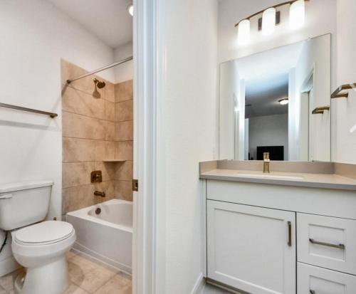 a white bathroom with a toilet and a sink at Prívate Room In Cypress in Hot Wells