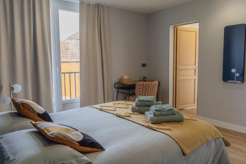 un grand lit dans une chambre avec une fenêtre dans l'établissement Magnum 80 Terrasse & Climatisation - 6 personnes - BnB Epernay, à Épernay