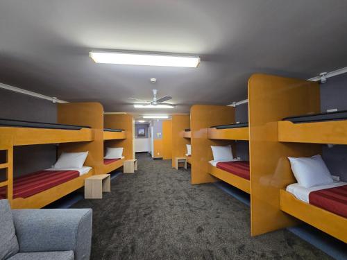 a room with yellow bunk beds and a couch at Bluewater Hotel in Napier