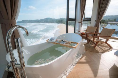 a bath tub with a view of the beach at Sunsea House-Đá Đĩa Phú Yên in Tuy An