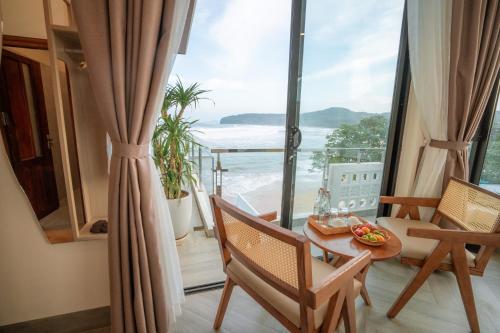 a room with a table and chairs and a view of the ocean at Sunsea House-Đá Đĩa Phú Yên in Tuy An