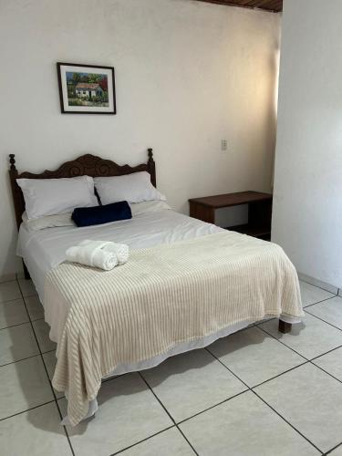 a bedroom with a large bed with white sheets at La Mar Paraty Hospedaria 04 in Paraty