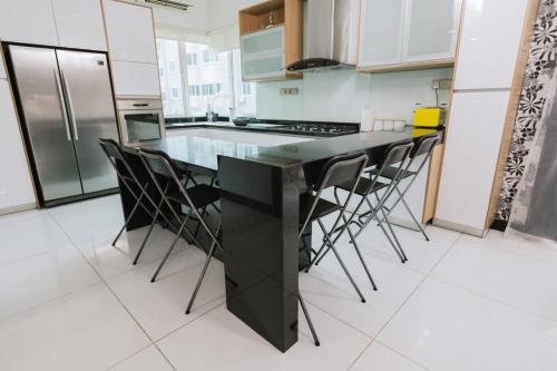 a kitchen with a black counter and stools at Chic 6BR Home Private Rooftop Garden Kemensah KL in Ampang