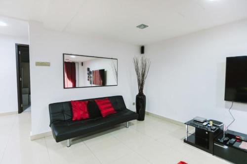 a living room with a black couch and a mirror at Chic 6BR Home Private Rooftop Garden Kemensah KL in Ampang