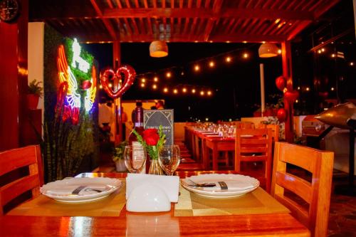 una sala da pranzo con tavolo, piatti e bicchieri di HOTEL LA PALMERA DE ORO a Tarapoto