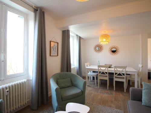 un salon et une salle à manger avec une table et des chaises dans l'établissement T3 Jardin Wifi La Bourboule, 5 pers - FR-1-608-283, à La Bourboule