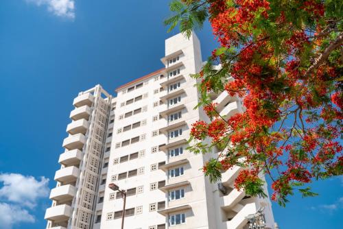 فندق إيست تشاينا سي في جزيرة إيشيغاكي: مبنى سكني أبيض مع أزهار حمراء