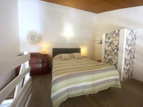 une petite chambre avec un lit et un miroir dans l'établissement Duplex rénové face à la plage avec balcon et parking - FR-1-738-41, à Saint-Palais-sur-Mer