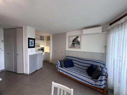 une chambre avec un lit avec une couverture rayée dans l'établissement Appartement 2 Pièces VUE MER avec Parking et Clim - 4 Pers - FR-1-731-124, au Grau-du-Roi