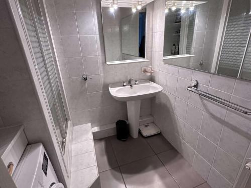 une salle de bain blanche avec un lavabo et un miroir dans l'établissement Appartement 2 Pièces VUE MER avec Parking et Clim - 4 Pers - FR-1-731-124, au Grau-du-Roi