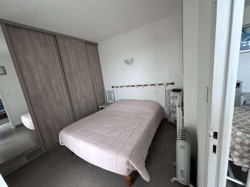 une petite chambre avec un lit dans une pièce dans l'établissement Appartement 2 Pièces VUE MER avec Parking et Clim - 4 Pers - FR-1-731-124, au Grau-du-Roi