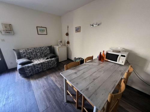 un salon avec une table en bois et un canapé dans l'établissement Appartement 2 pièces avec terrasse, parking, proche plage pour 4 personnes - FR-1-701-86, à Valras-Plage