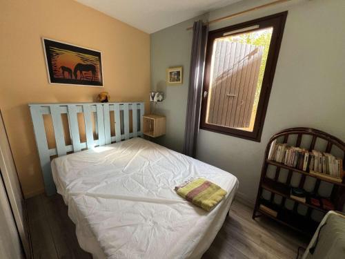 une chambre avec un lit blanc et une fenêtre dans l'établissement Appartement 2 pièces avec terrasse, parking, proche plage pour 4 personnes - FR-1-701-86, à Valras-Plage