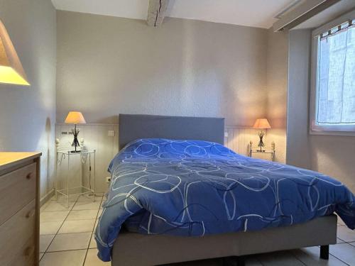 une chambre avec un lit avec une couette bleue dans l'établissement Appartement 2 pièces rénové au cœur de Banyuls, climatisé, proche plage - FR-1-225C-157, à Banyuls-sur-Mer
