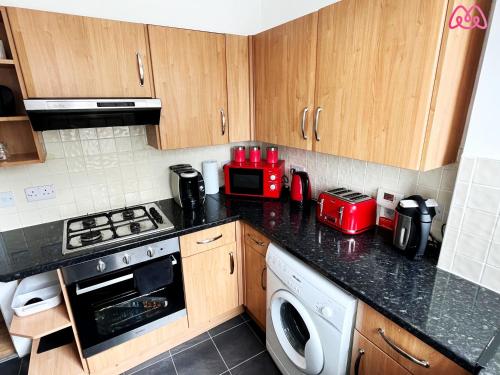 a kitchen with a stove top oven next to a microwave at 2 Bedrooms Entire Apartment Self Check in in Fife