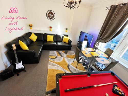 a living room with a black couch and a pool table at 2 Bedrooms Entire Apartment Self Check in in Fife