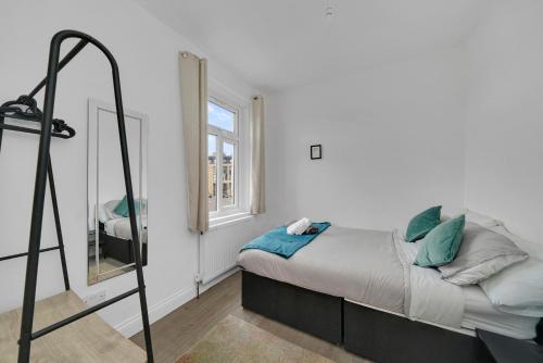 a small bedroom with a bed and a mirror at Startlet Stays Apartments - On Elizabeth Line with Free Parking in London