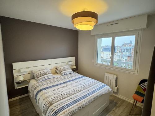 une chambre avec un lit avec une grande fenêtre dans l'établissement Joli appartement 2 pièces avec balcon et parking à Villers-sur-Mer - FR-1-712-90, à Villers-sur-Mer