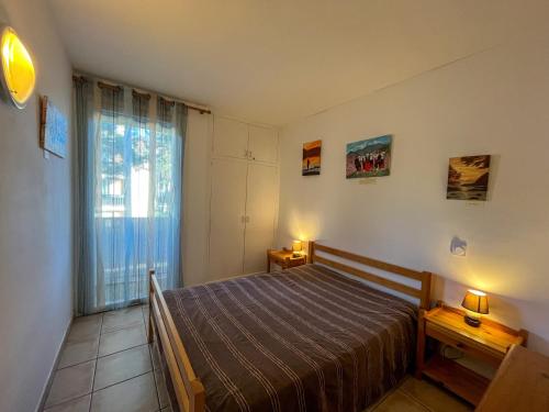 une chambre avec un lit et une grande fenêtre dans l'établissement Argelès-Plage: T2 confortable, proche mer et commerces - FR-1-753-28, à Argelès-sur-Mer