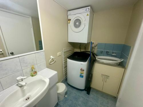 une salle de bain avec un lavabo et une machine à laver dans l'établissement Escape to Villa 4 - Cape View Resort, à Broadwater