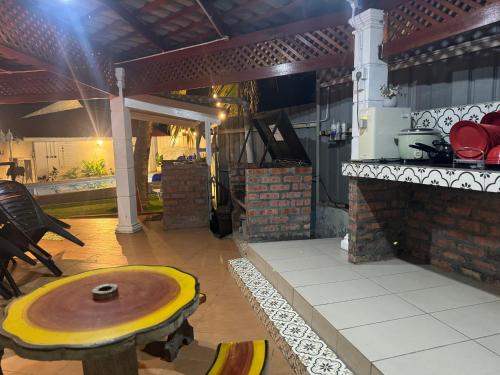 a kitchen with a wooden table in a room at Jas Telaga Inn Homestay in Teluk Mas