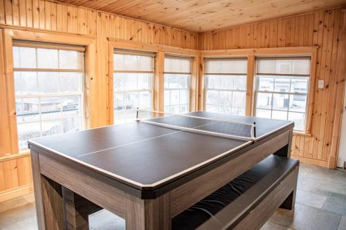 a ping pong table in a room with wooden walls at Discovery Retreat - Heated Pool, Jacuzzi, Game Room, Sauna in Penetanguishene