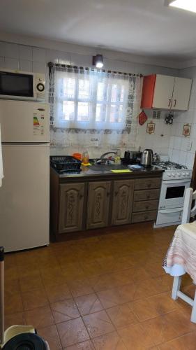 eine Küche mit einem weißen Kühlschrank und einer Spüle in der Unterkunft Dúplex Complejo “Poker” in Villa Gesell
