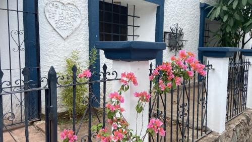 a house with a gate with flowers on it at Recamara Colonial in Álamos