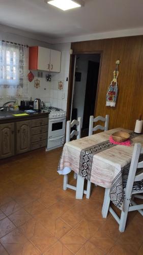 eine Küche mit einem Tisch und Stühlen sowie eine Küche mit einem Herd in der Unterkunft Dúplex Complejo “Poker” in Villa Gesell